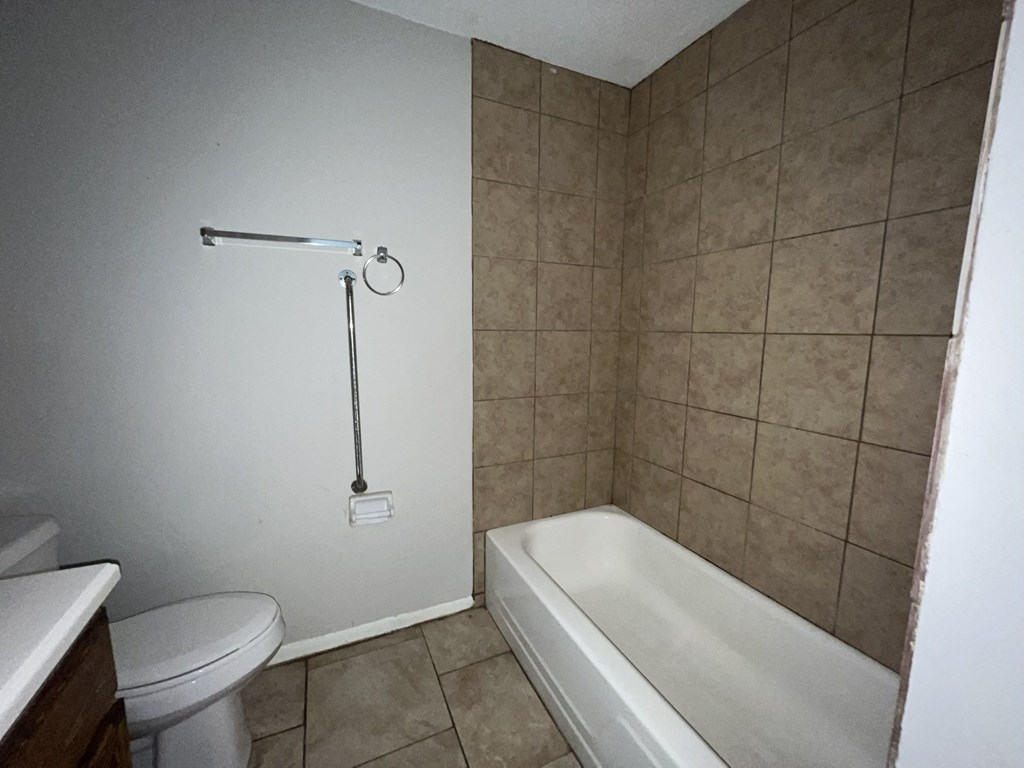 a bathroom with a toilet and a tub and a sink