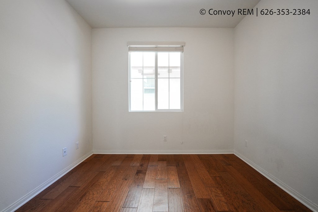 the interior of an empty room with wooden floors and a window