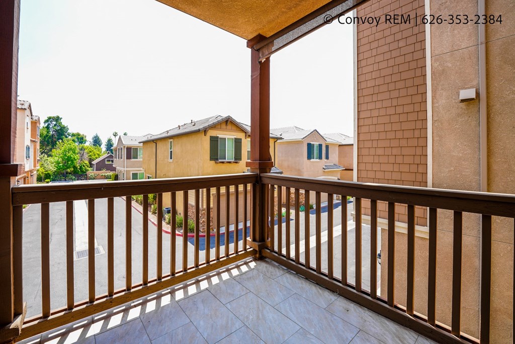 a balcony with a view of the yard and a pool
