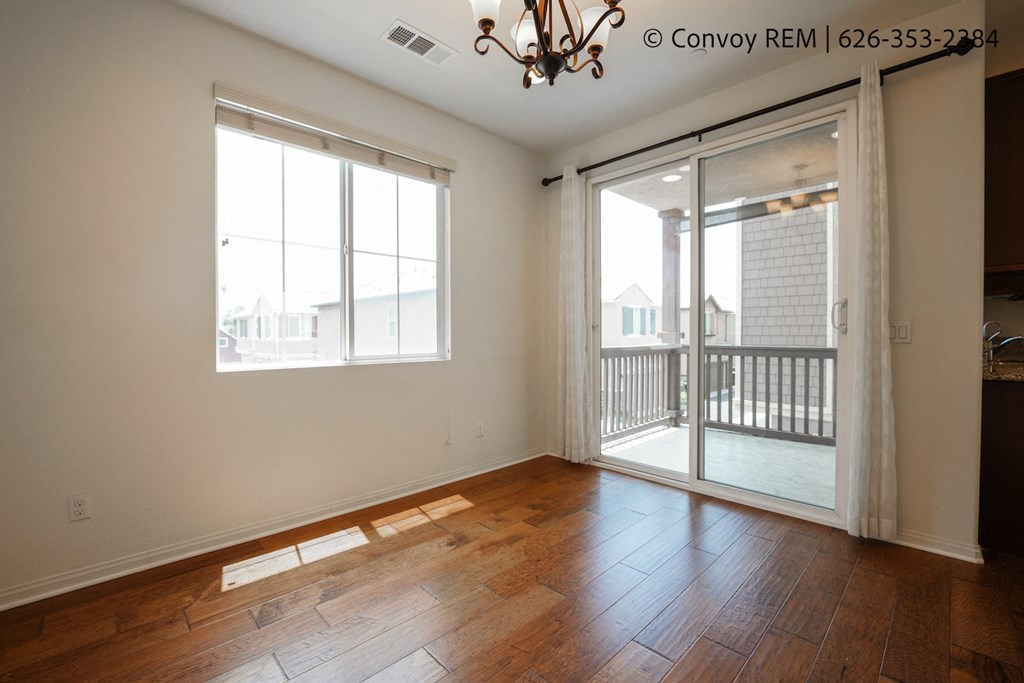 an empty living room with sliding glass doors to a balcony