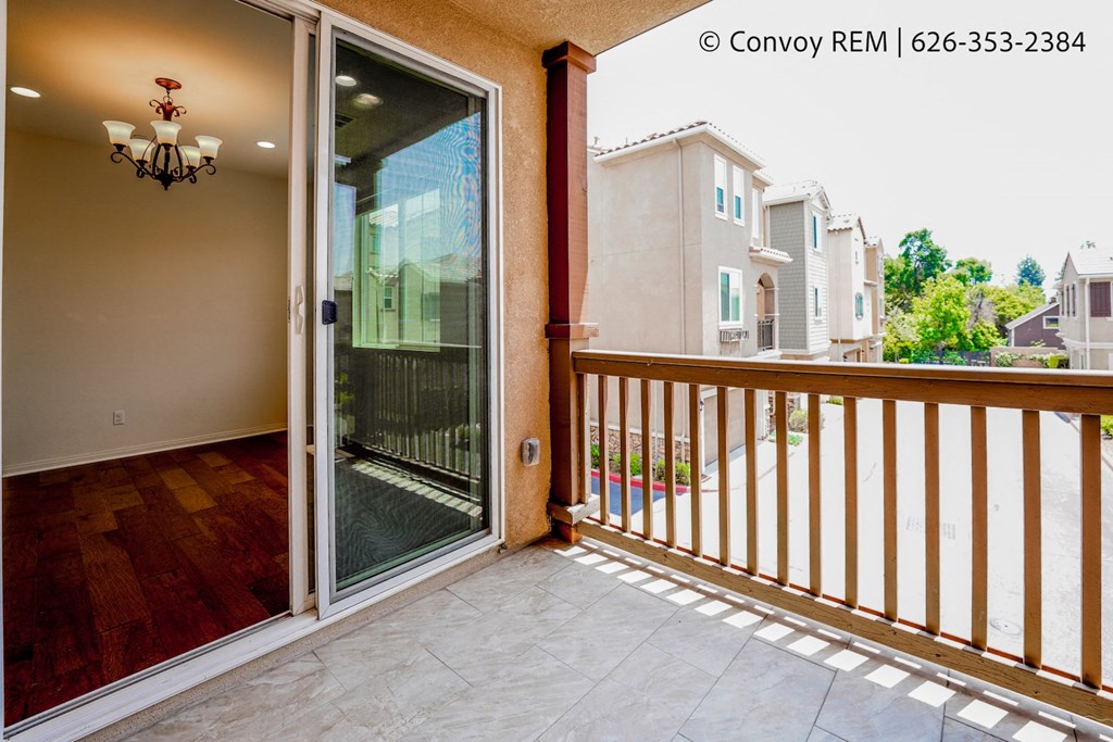 a balcony with a sliding glass door and a wooden railing