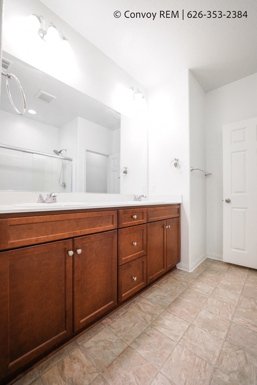 a bathroom with wooden cabinets and a large mirror