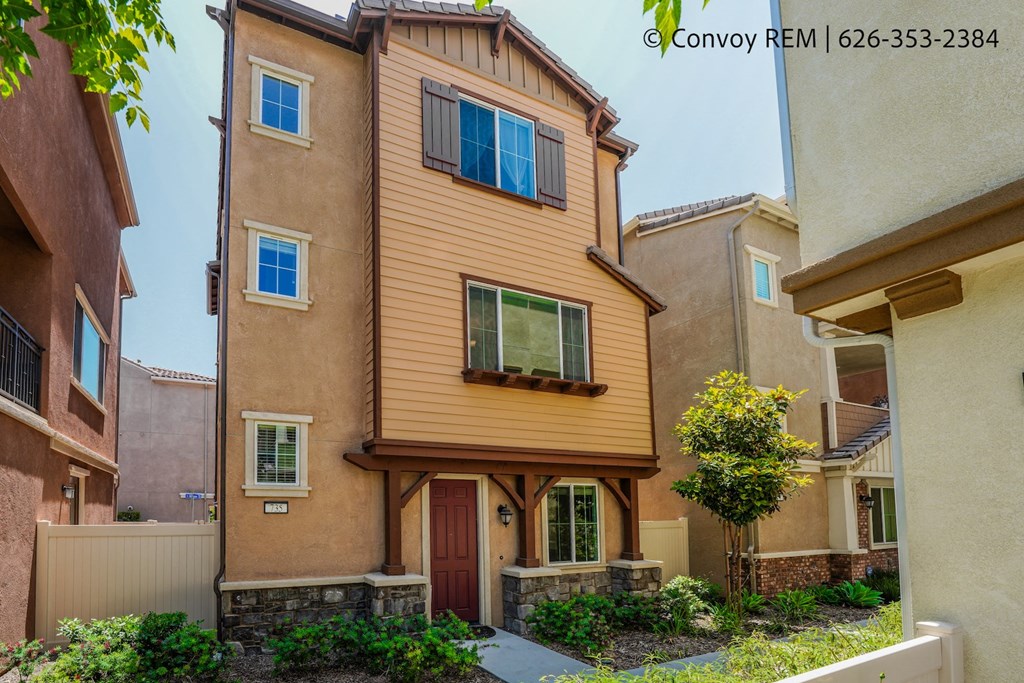 a yellow house with a red door and a sidewalk
