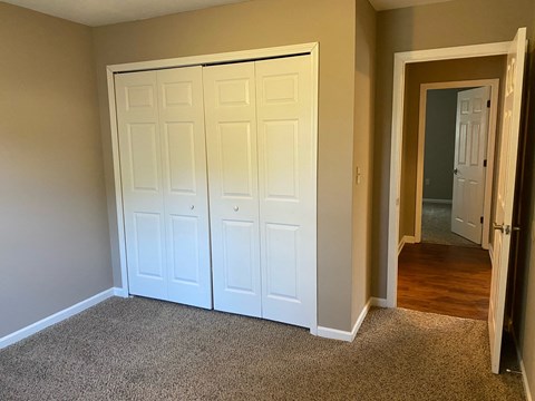 a bedroom with two closets and a door to a hallway