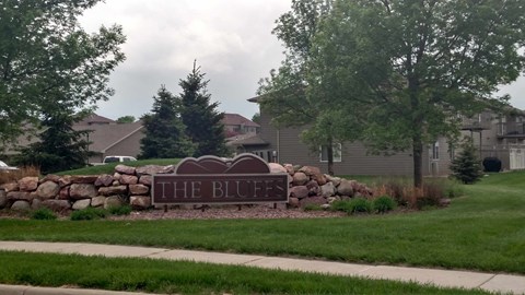 A sign that says "The Bluff" in front of a residential area.