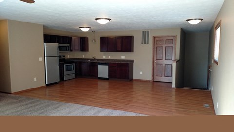 A kitchen with a refrigerator, microwave, oven, and cabinets.