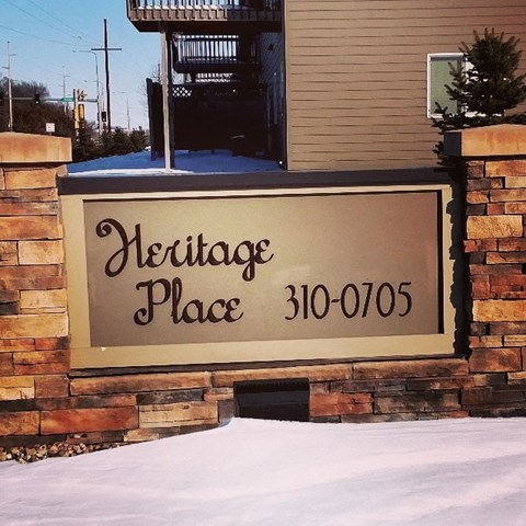 A sign that says Heritage Place with a phone number on it.