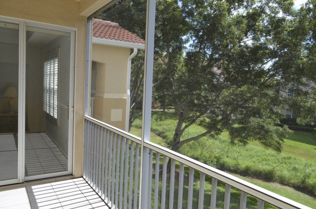 a balcony or terrace with a view of a tree