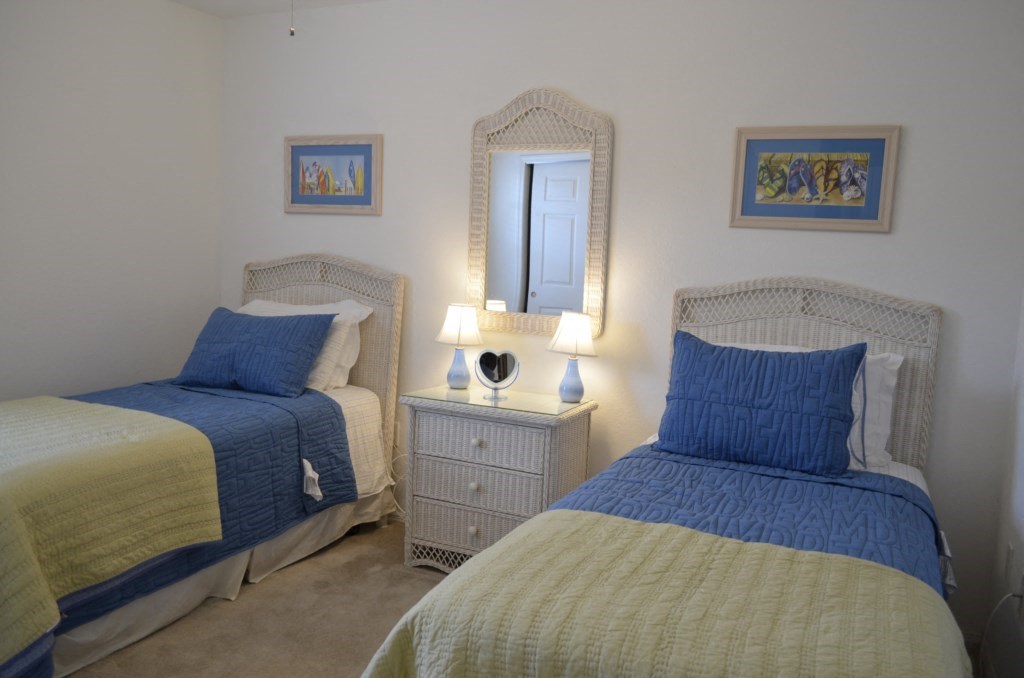 two twin beds in a room with a mirror