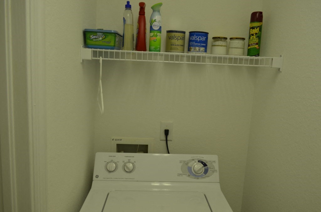 the laundry room has a white stove and a shelf above it