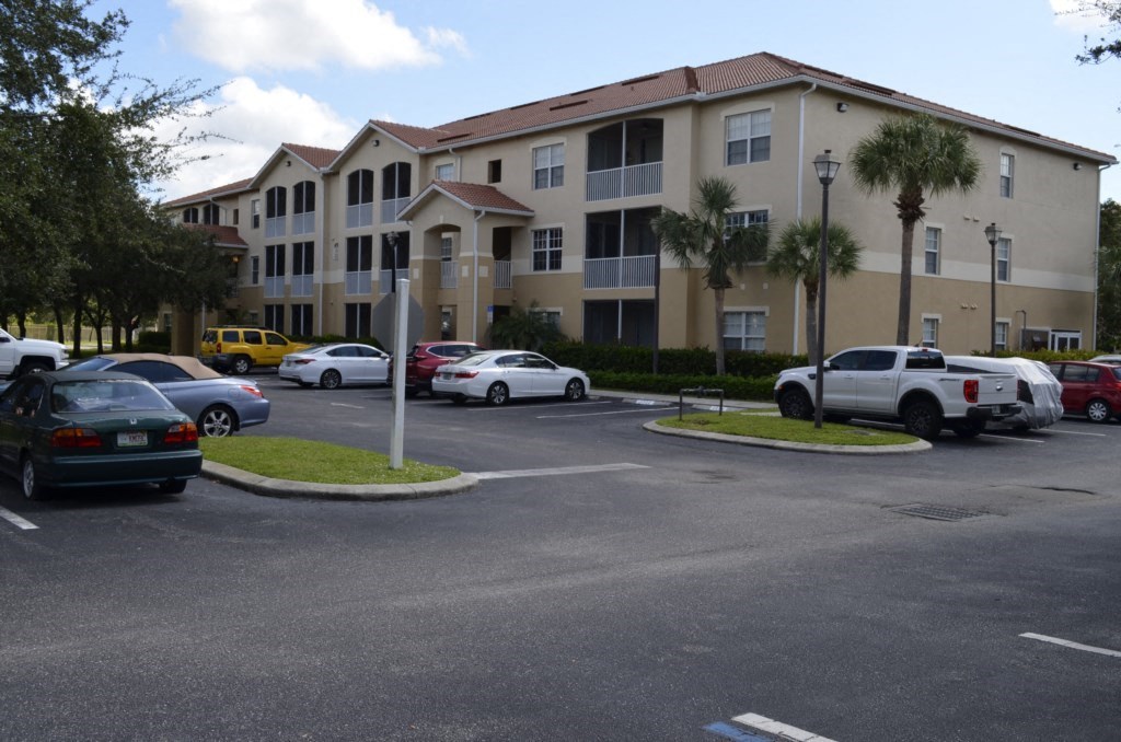 a parking lot with cars in front of an apartment building