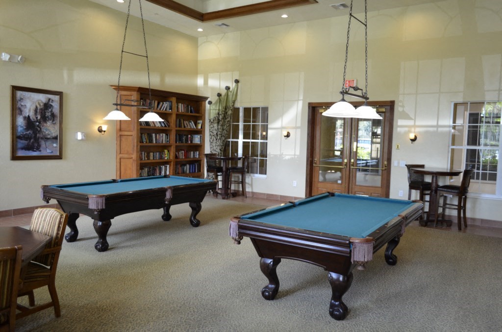 two pool tables in the center of a room with chairs and tables