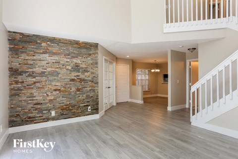 A spacious room with a stone wall and wooden flooring.