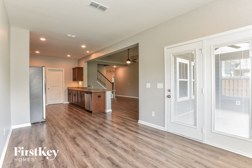 the living room and kitchen of a house with a wood floor