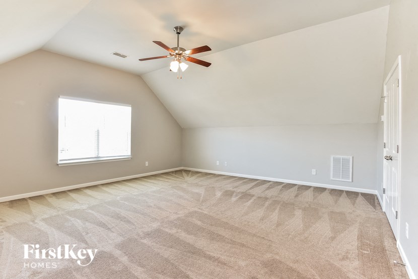 an empty room with a ceiling fan and a window