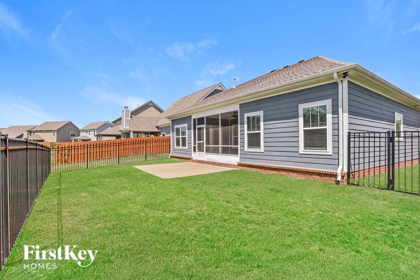 a blue house with a yard and a fence