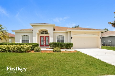 A house with a red door and a sign that says "FirstKey Homes".