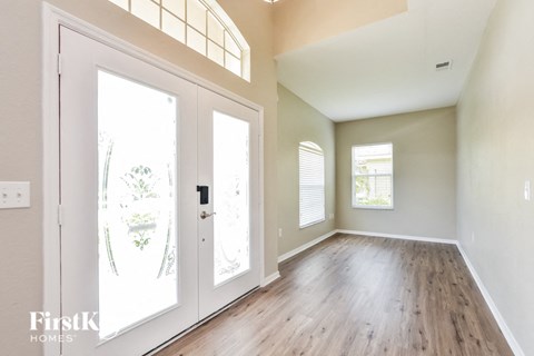 A room with a white door and a window with blinds.