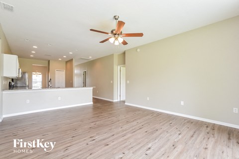 A spacious room with a ceiling fan and wooden flooring.