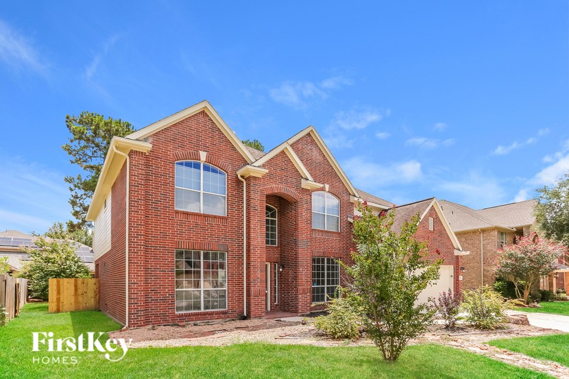 A brick house with a tree in front of it.