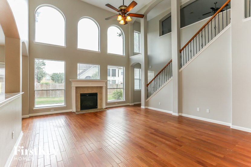 A large open room with a wood floor and a fireplace.