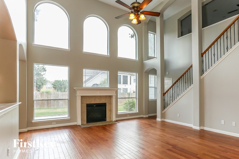 A large open living room with a fireplace and a staircase.