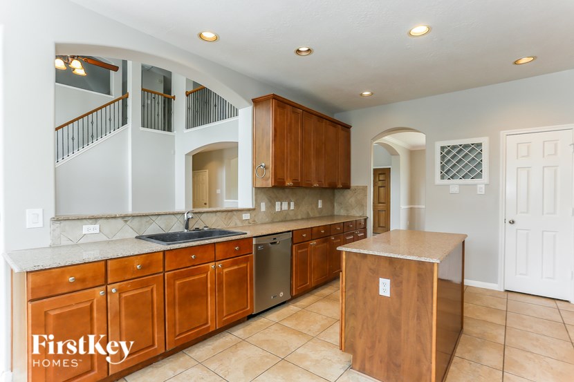 A kitchen with wooden cabinets and a marble countertop.