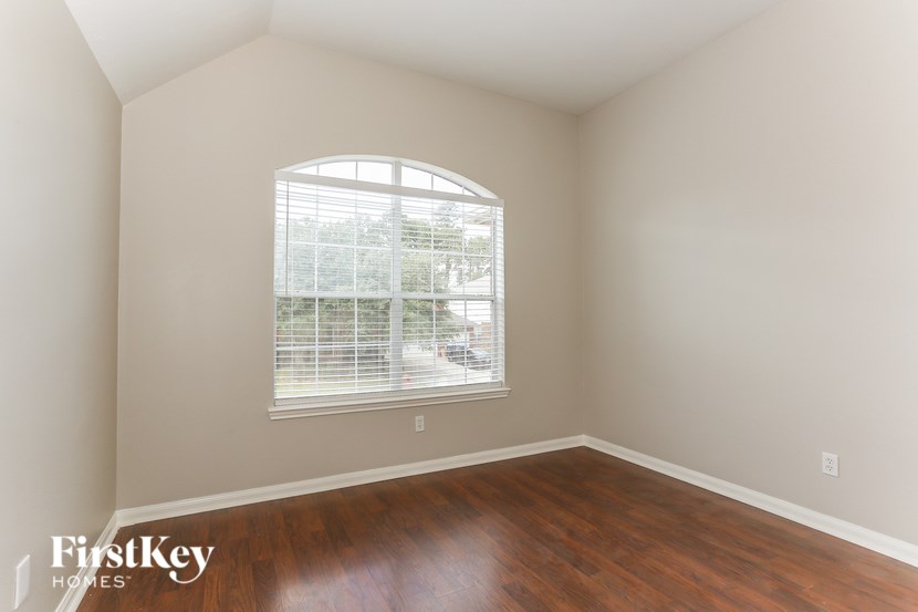 A room with a window and wooden floors.