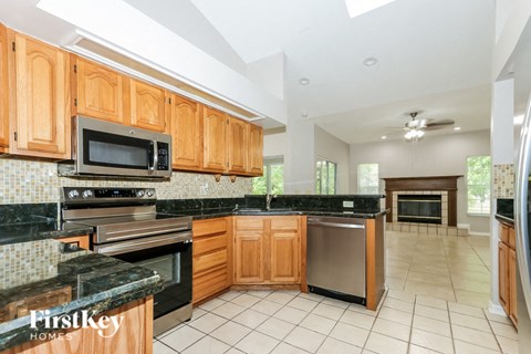 A kitchen with wooden cabinets and black granite countertops.