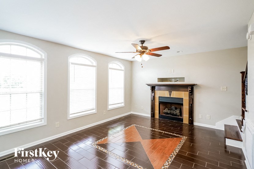 a living room with a fireplace and a ceiling fan
