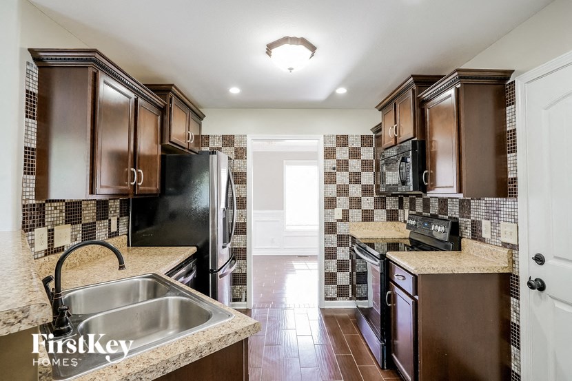 a kitchen with a sink and a stove and a refrigerator
