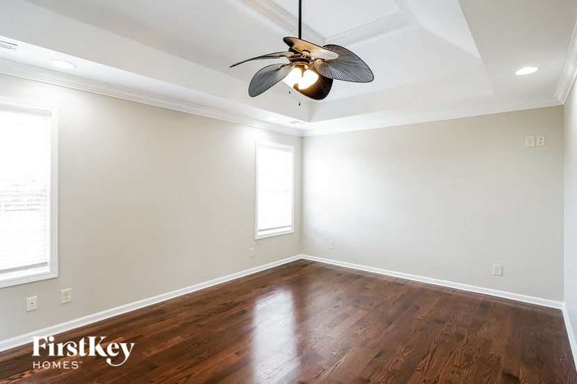 a empty room with a ceiling fan and wood floors