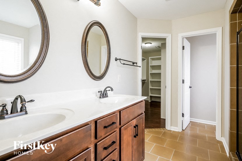 a bathroom with two sinks and a mirror and a closet
