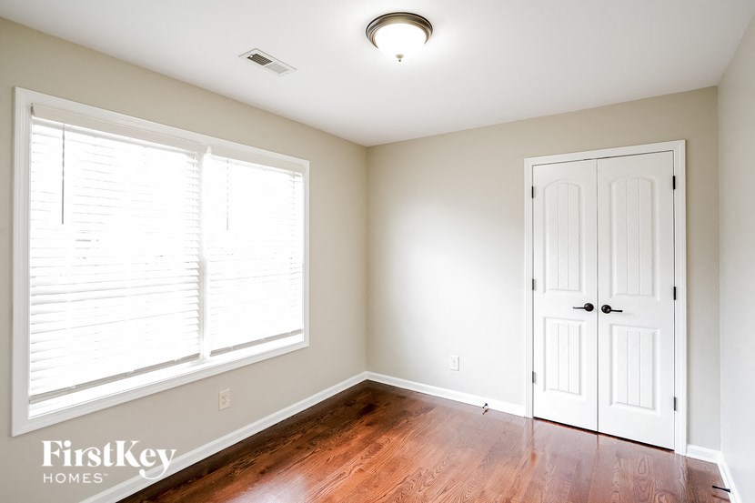 an empty room with wood floors and a white door and window