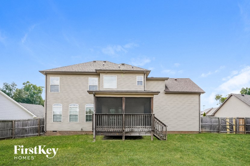the back of a house with a deck and a yard