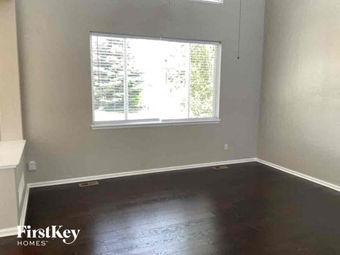 an empty room with wooden floors and a window