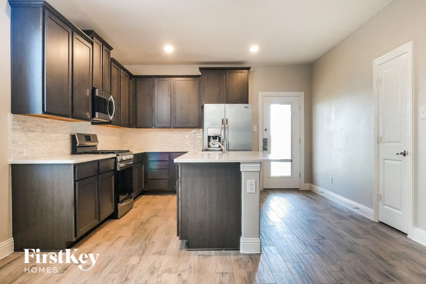 a kitchen with black cabinets and a white counter top