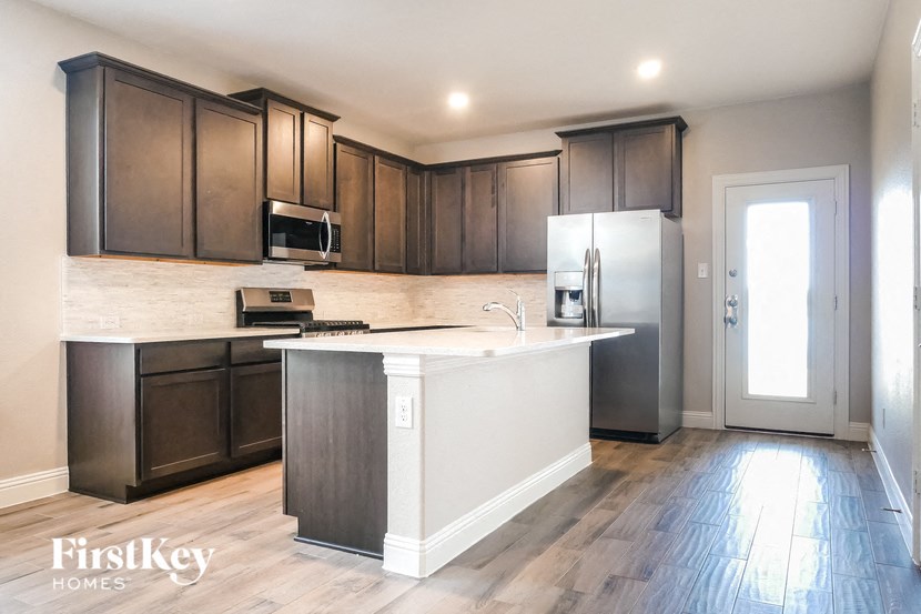 a kitchen with dark wood cabinets and a white counter top