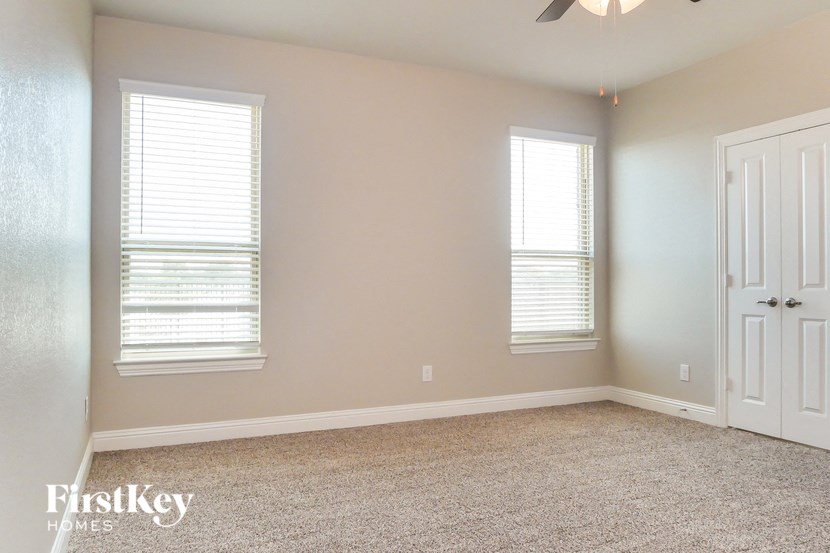 a empty room with two windows and a white door