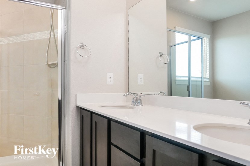 a white bathroom with two sinks and a shower