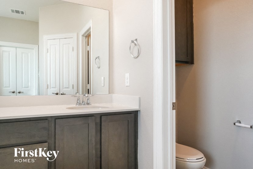 a bathroom with a sink toilet and a mirror