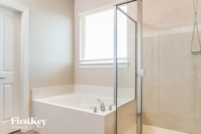 a white bathroom with a shower and a sink
