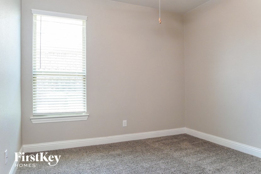 a empty room with a window and a carpet