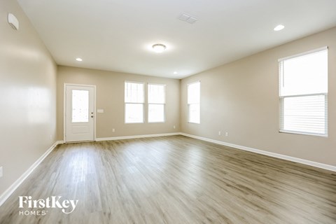 an empty living room with white walls and wood floors