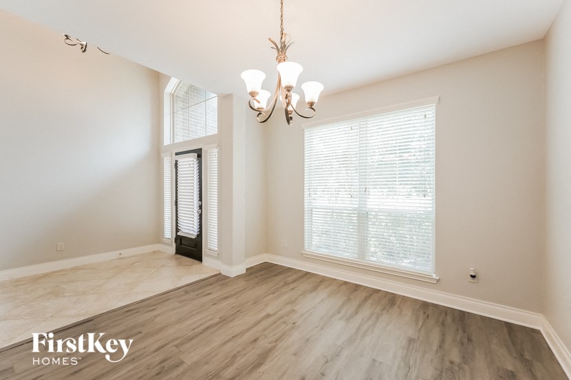 a living room with a chandelier and large windows