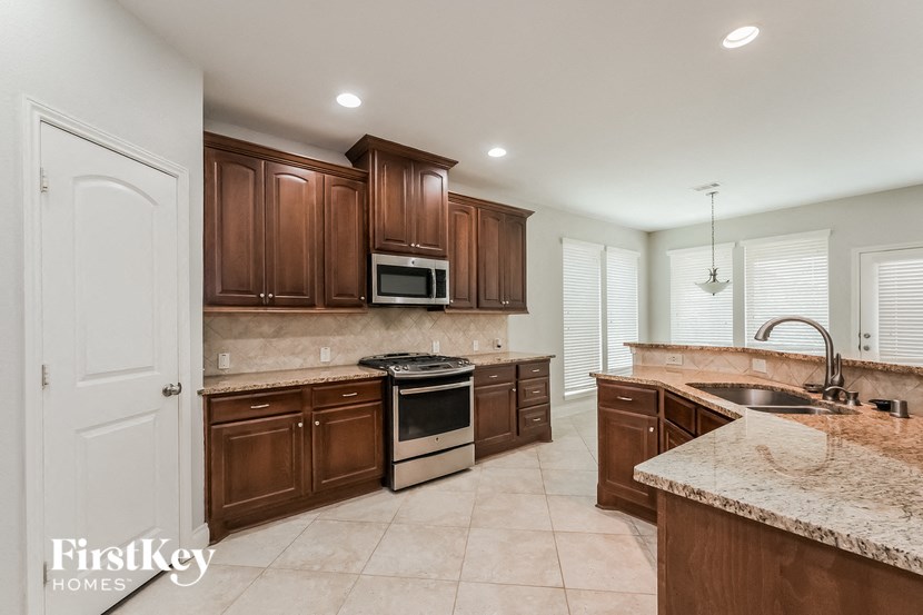 a kitchen with wooden cabinets and granite counter tops and a sink