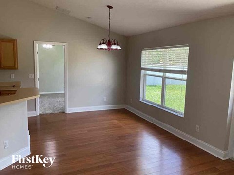 an empty living room with wood floors and a window