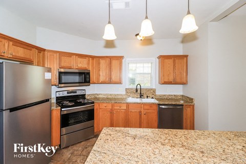 A kitchen with wooden cabinets and a granite countertop.