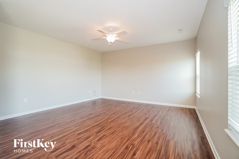 A room with wooden flooring and a ceiling fan.