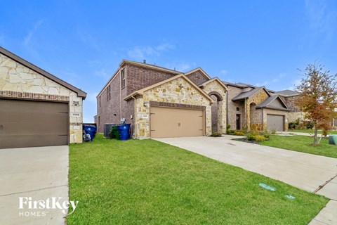 A house with a garage and a driveway in front of it.
